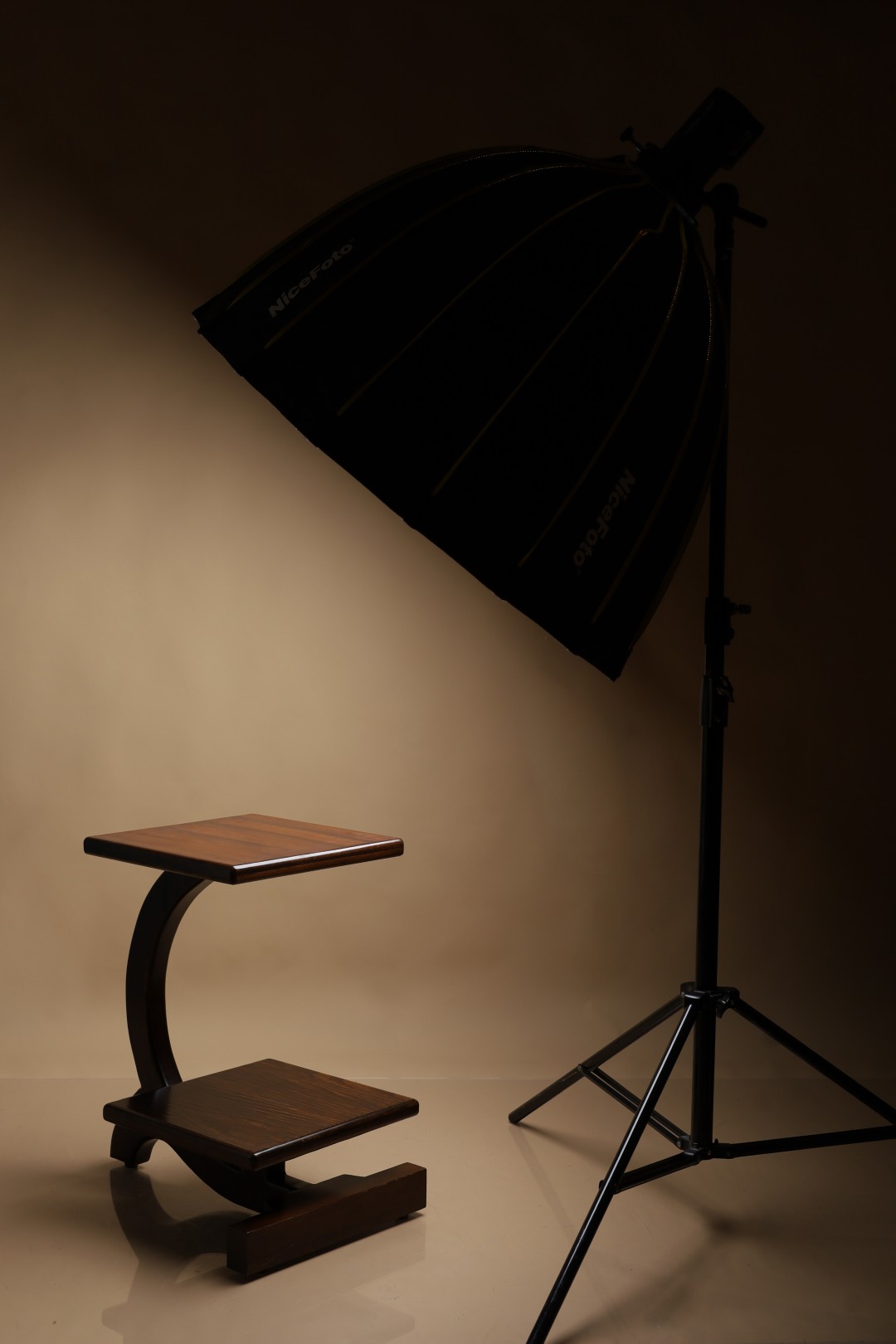 A finished Redmoor side table lit under a studio softbox in the Aleppo workshop